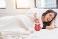 Alarm clock has a nice day with happiness Young asian woman with smile face and healthy background Beautiful girl hold alarm clock