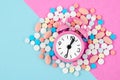 The alarm clock and many drug on a pink colour background. Taking medicine at the right time concepts