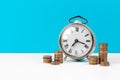 Alarm clock and money coins on the table. Royalty Free Stock Photo