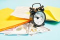 Alarm clock, money and parcels on blue background, mail concept, tracking parcels