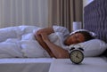 Alarm clock on nightstand near sleeping young man Royalty Free Stock Photo