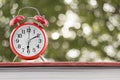 Alarm clock on a notebook with abstract nature blur background Royalty Free Stock Photo