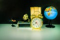 Alarm clock old vintage gold and globe plastic - book, gramophone over white on black background