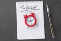 Alarm clock over spiral note pad with the to do list as a time management concept Royalty Free Stock Photo