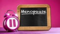Alarm Clock with Pause Symbol and Blackboard with Text Menopause - Generative Ai