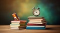 Alarm clock, pencils stand on stack of colored books on a wooden table, green background, copy space, back to school concept