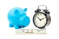 Alarm clock, piggy bank, and dollar banknote