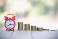 Alarm clock and a pile of golden coins on the table, Concept of opportunity cost time and Money saving Royalty Free Stock Photo