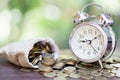 Alarm clock and a pile of golden coins on the table, Concept of opportunity cost time and Money saving. Investment risk Royalty Free Stock Photo