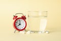 Alarm clock, pills and glass of water on background, close up Royalty Free Stock Photo