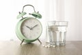 Alarm clock, pills and glass of water on table, close up Royalty Free Stock Photo