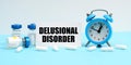 An alarm clock, pills, injections and a card with the inscription - Delusional Disorder