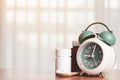 An alarm clock with pills on the wooden spoon and medicine bottles on the table Royalty Free Stock Photo