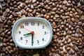 The alarm clock is placed on top of the roasted Arabica coffee beans. Royalty Free Stock Photo
