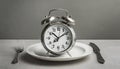 Alarm clock and plate with cutlery . Concept of intermittent fasting, lunchtime, diet and weight loss Royalty Free Stock Photo