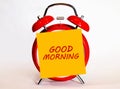 An alarm clock and a yellow note with text Good Morning