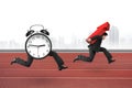 Alarm clock running after man carrying red arrow up Royalty Free Stock Photo