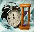 Alarm-clock and sandglass on b