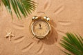 Alarm clock on a sandy beach. Noon, 12 p.m. Royalty Free Stock Photo