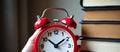 alarm clock scene, clock and textbooks for class schedule, red alarm clock with textbooks for classroom routine setup Royalty Free Stock Photo