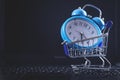 Alarm clock with shopping cart on computer keyboard Royalty Free Stock Photo