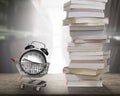 Alarm clock in shopping cart, stack of books, wooden desk