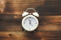 Alarm clock showing almost 12 o clock, on old wooden floor background Royalty Free Stock Photo