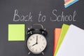 He alarm clock shows the time eight hours against the background of the chalk board and school subjects, it`s time to go to schoo Royalty Free Stock Photo