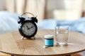 alarm clock, sleeping pills and glass of water Royalty Free Stock Photo