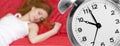 Alarm clock and sleeping young woman Royalty Free Stock Photo