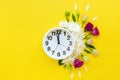Alarm clock with small burgundy red roses, white peonies and petals Royalty Free Stock Photo