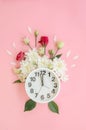 Alarm clock with small burgundy red roses, white peonies and petals Royalty Free Stock Photo