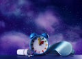 Alarm clock, soporific pills and sleeping mask on blue wooden table against night sky with stars. Insomnia Royalty Free Stock Photo