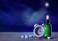 Alarm clock and soporific remedies on wooden table against night sky with stars, space for text. Insomnia Royalty Free Stock Photo