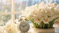 Alarm clock among spring flowers, daylight saving time concept. Lose an hour, spring forward