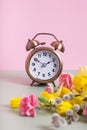 Alarm clock with spring flowers. Spring time, daylight savings concept, spring forward Royalty Free Stock Photo