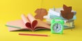 Alarm clock, stack of books and stationery on yellow background, back to school, holidays, education Royalty Free Stock Photo