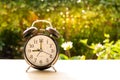 The alarm clock stack on wood table and sunset background in the public park. Royalty Free Stock Photo