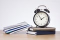 Alarm clock standing on pile of books Royalty Free Stock Photo