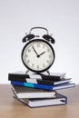 Alarm clock standing on pile of books Royalty Free Stock Photo