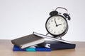 Alarm clock standing on pile of books Royalty Free Stock Photo
