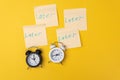 Alarm clock with a sticky note with text later. Procrastination, delay and urgency concept