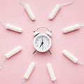 alarm clock surrounded by tampons. High quality photo