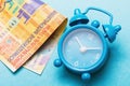 Alarm clock and Swiss francs on a blue background. Concept time money Royalty Free Stock Photo