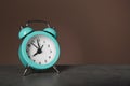 Alarm clock on table against dark color background. Time management concept Royalty Free Stock Photo