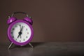 Alarm clock on table against dark color background. Time management concept Royalty Free Stock Photo