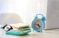 Alarm clock on a table with laptop computer and books. Royalty Free Stock Photo