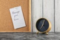 Alarm clock on table and sheet of paper with phrase \