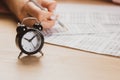 Alarm clock with time running out. Students hands to take exams, write examination room with pencil holding on optical form of Royalty Free Stock Photo