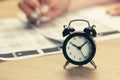 Alarm clock with time running out. Students hands to take exams, write examination room with pencil holding on optical form of Royalty Free Stock Photo